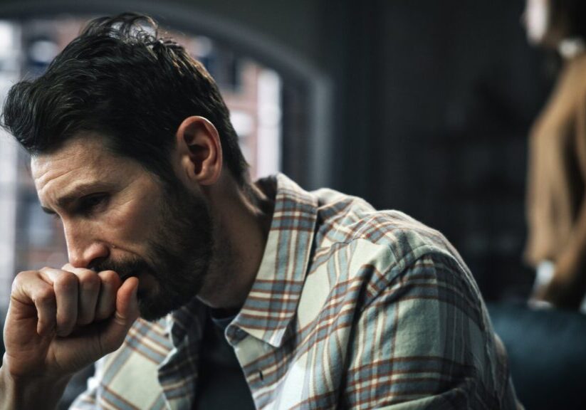 Portrait of Fragile Crying Man being Harrased and Bullied by Partner. Couple Arguing and Fighting Violently. Domestic Violence, Emotional Abuse, Toxic Behavior. Rack Focus with Girfriend Screaming